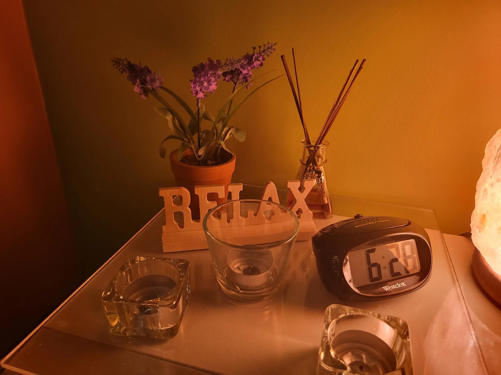 Bedside table with a wooden RELAX sign, tea lights and lavender